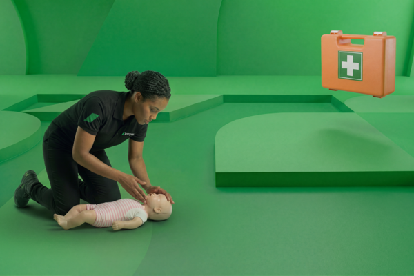 EHBO instructeur past de lift-kantelmethode toe bij een babypop tijdens de cursus EHBO voor kinderen cursus