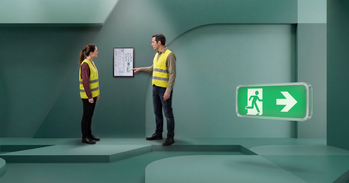 Twee BHV'ers bespreken de ontruimingsplattegrond en de vluchtroute naar de nooduitgang